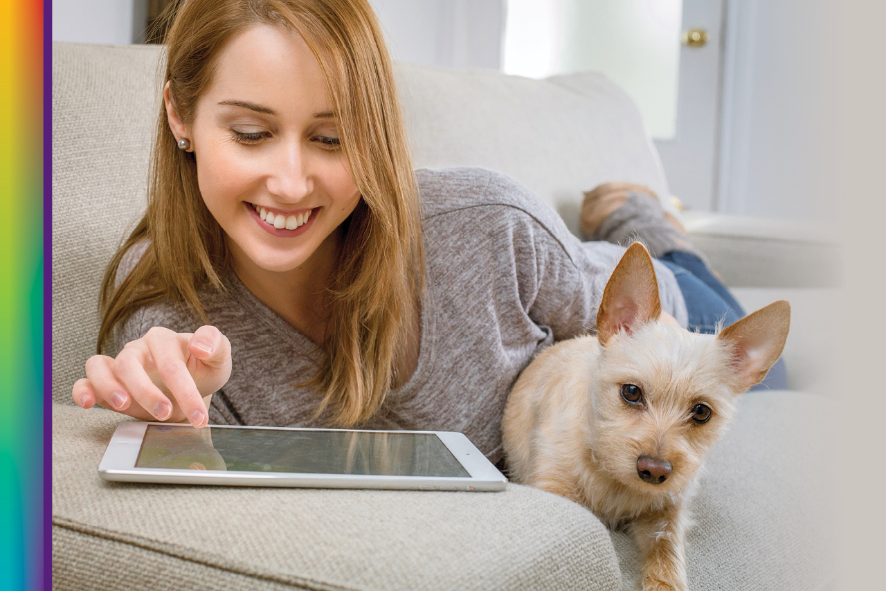 image of a person using a tablet with their dog