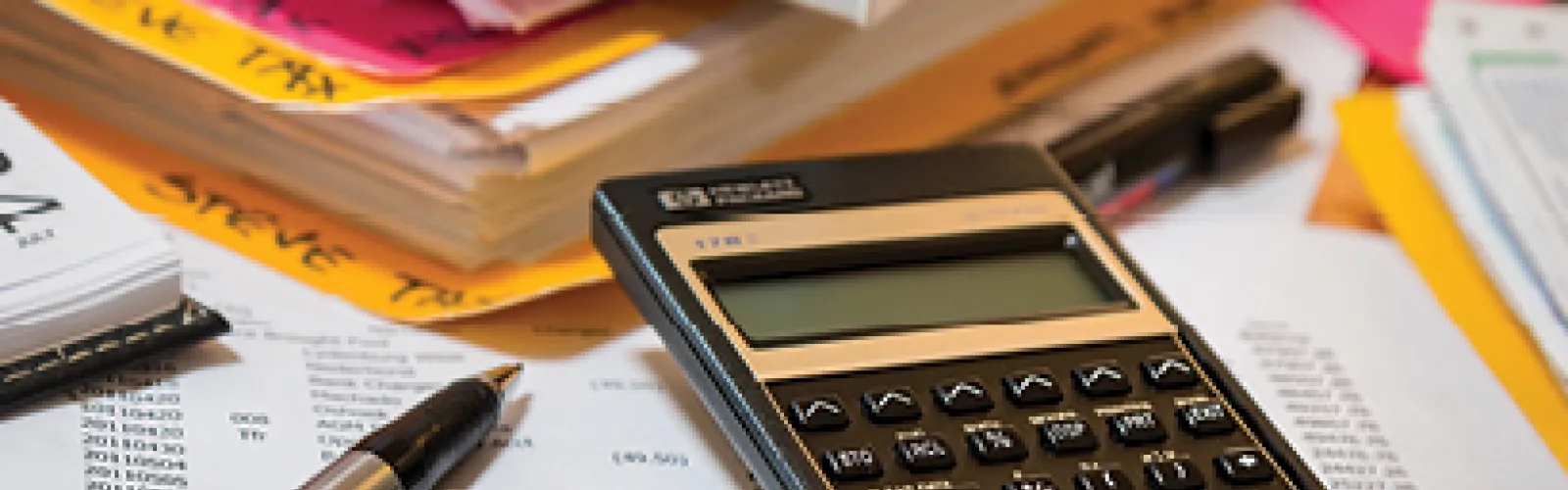 A calculator and tax forms on desk